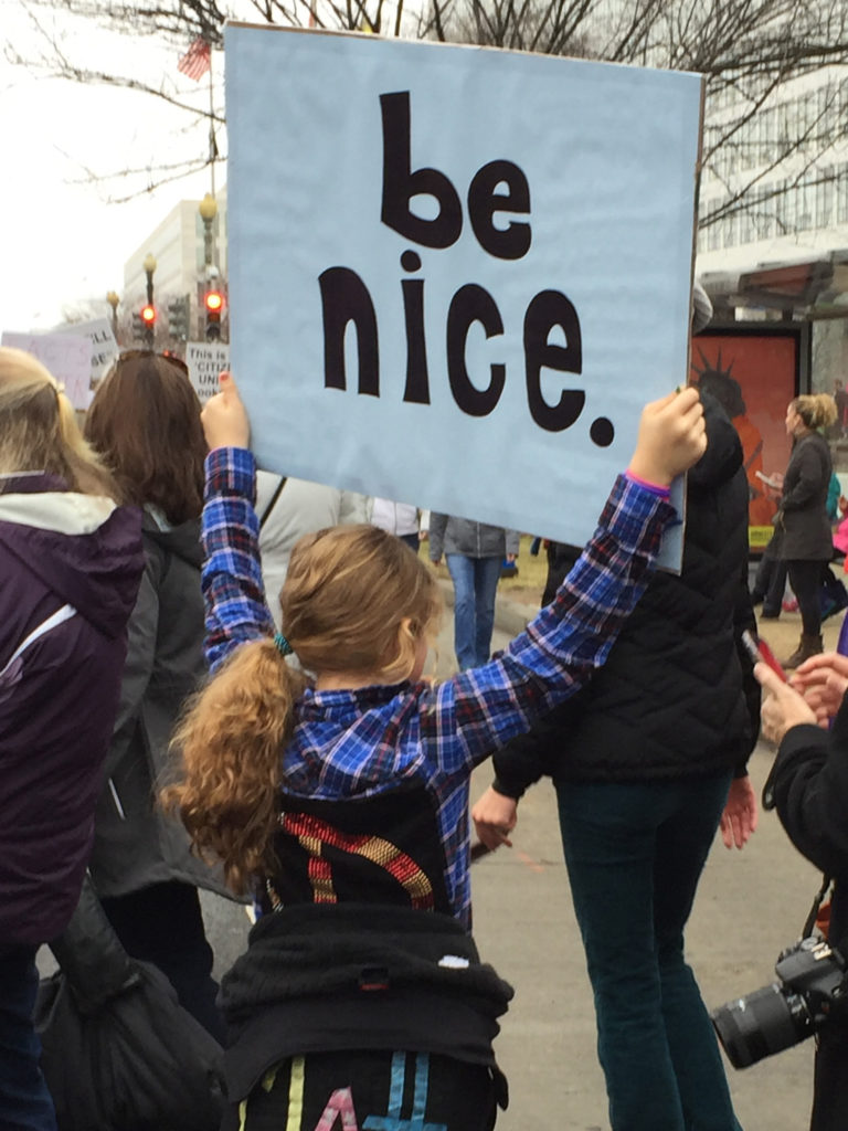 Young girl holding a sign saying Be Nice